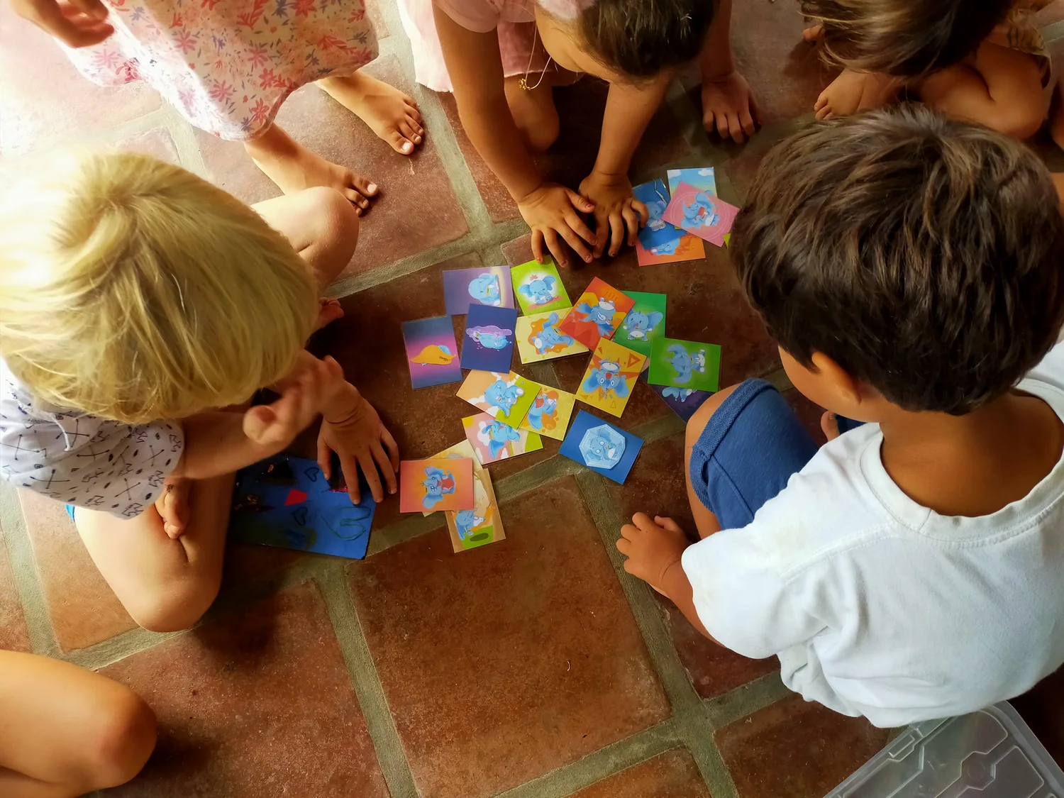 Children gathered on the floor, choosing and comparing colourful elephant emotion cards.