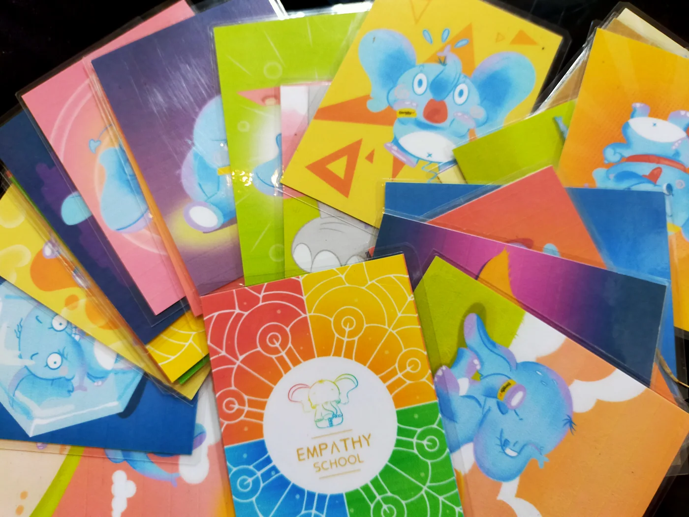 Printed Empathy School cards spread out together, showing the elephant character expressing different feelings.